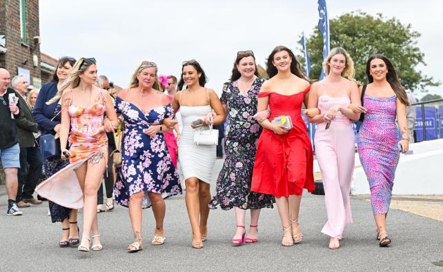 A group of women link arms in a range of vibrant outfits Image Simon Dack